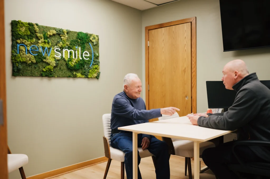 Senior man smiling at his free dental implant consultation at New Smile Columbus Dental Implant Studio.